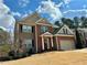 Charming two-story home features a combination of brick and siding with a well-manicured lawn and attached garage at 5305 Redfield Way, Cumming, GA 30028