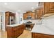 A spacious kitchen with wooden cabinetry, a center island, stainless steel appliances and white countertops at 5305 Redfield Way, Cumming, GA 30028