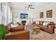 Cozy living room featuring a fireplace, large leather couches, a ceiling fan, and rustic decor at 5305 Redfield Way, Cumming, GA 30028