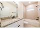 Bathroom with granite countertop, sink, and tiled bathtub-shower combo at 1467 Lockwood Sw Dr, Atlanta, GA 30311