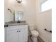 Modern half bathroom with granite countertop, white cabinet, updated fixtures and laminate floors at 1467 Lockwood Sw Dr, Atlanta, GA 30311