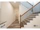 Hallway showcasing the staircase with dark metal balusters and a view into the kitchen at 1467 Lockwood Sw Dr, Atlanta, GA 30311