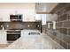 Close-up of the kitchen featuring stainless steel appliances, granite countertops, and gray subway tile backsplash at 1467 Lockwood Sw Dr, Atlanta, GA 30311