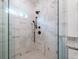 Close-up of modern shower featuring marble-look tiling and black fixtures at 1467 Lockwood Sw Dr, Atlanta, GA 30311