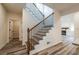 Staircase featuring dark metal balusters, wooden handrail, and view of the kitchen and living room at 1467 Lockwood Sw Dr, Atlanta, GA 30311