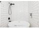 Modern bathroom featuring a soaking tub, black fixtures, and subway tile surround with a built-in niche at 2720 Creekview Nw Pt, Marietta, GA 30064