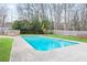 A serene swimming pool with a clear blue water, set amidst a well-maintained yard with mature trees at 2720 Creekview Nw Pt, Marietta, GA 30064