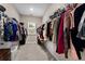 Walk-in closet featuring carpet, natural light from a window, and ample hanging storage for clothes at 380 Parkside Meadow Sw Dr, Marietta, GA 30064