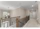 Upstairs hallway featuring neutral walls and carpet with modern black metal railings and natural light from a window at 380 Parkside Meadow Sw Dr, Marietta, GA 30064