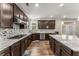 Bright, modern kitchen with dark cabinets, granite countertops, stainless appliances, and center island with pendant lighting at 380 Parkside Meadow Sw Dr, Marietta, GA 30064