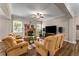 Living room with hardwood floors, fireplace, large windows, and multiple seating options at 380 Parkside Meadow Sw Dr, Marietta, GA 30064