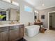 Bright bathroom with dual vanities, standalone tub, and natural light from a window at 3909 Enclave Way, Tucker, GA 30084