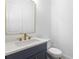 Powder room featuring a navy vanity with gold fixtures and white countertop and toilet at 3909 Enclave Way, Tucker, GA 30084