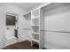 Modern walk-in closet with white shelving and metal rods for hanging clothes, offering ample storage space at 3909 Enclave Way, Tucker, GA 30084