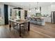 Dining area with a modern light fixture and an open view of the kitchen and outdoor patio at 3909 Enclave Way, Tucker, GA 30084