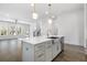 Kitchen island features a farmhouse sink, seating, and modern fixtures with an open concept floor plan at 3909 Enclave Way, Tucker, GA 30084