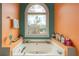 Relaxing bathtub with a large arched window and colorful decor at 4283 Northwind Dr, Ellenwood, GA 30294