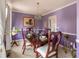 Formal dining room with elegant chandelier, dark wood table, and purple walls at 4283 Northwind Dr, Ellenwood, GA 30294