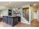 Basement bar featuring granite countertop, wooden cabinets, and access to the staircase at 445 Edenbrooke Way, Roswell, GA 30075