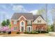 Charming brick home featuring a manicured lawn, blooming trees, and a welcoming front entrance at 445 Edenbrooke Way, Roswell, GA 30075