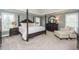 Spacious main bedroom with a four-poster bed, sitting area, and serene color scheme at 445 Edenbrooke Way, Roswell, GA 30075