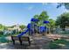 Community playground with swings, slides, and a wooden bench, surrounded by shade trees at 445 Edenbrooke Way, Roswell, GA 30075