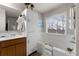 Bathroom features a tub with marble surround, white shelving, and wood vanity at 5211 Centennial Hill Nw Dr, Acworth, GA 30102