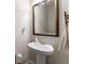Elegant half-bathroom with a pedestal sink, framed mirror, and modern fixtures at 5211 Centennial Hill Nw Dr, Acworth, GA 30102
