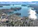 A picturesque aerial view showing a waterfront home, surrounded by lush trees and pristine blue waters at 7875 Robin Rd, Cumming, GA 30041
