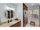 Bathroom featuring a granite vanity, decorative lighting, and ample wood storage at 7875 Robin Rd, Cumming, GA 30041