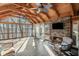 Screened-in porch with wood ceiling, stone fireplace, and lake views at 7875 Robin Rd, Cumming, GA 30041