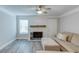 Open-concept living room with fireplace, ceiling fan, and neutral-toned sectional at 2340 Beaver Ruin Rd # Un62, Norcross, GA 30071