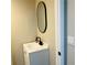 A clean bathroom featuring modern sink, black faucet, an oval mirror on beige colored wall and a white door at 2769 Glenwood Se Ave, Atlanta, GA 30317