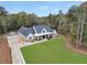 Stunning aerial view of a farmhouse with ample land, featuring lush lawn and a long driveway at 3911 Peeksville Rd, Locust Grove, GA 30248