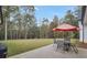 Spacious backyard featuring a patio with seating and a lush lawn bordered by mature trees at 3911 Peeksville Rd, Locust Grove, GA 30248