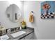 Charming powder room with a decorative mirror, granite countertop, and floral artwork at 3911 Peeksville Rd, Locust Grove, GA 30248
