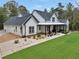 Beautiful modern farmhouse boasts a side-entry garage, landscaped front yard, and welcoming covered porch at 3911 Peeksville Rd, Locust Grove, GA 30248