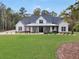 Stunning modern farmhouse featuring a covered front porch, black trim windows, and a lush green lawn at 3911 Peeksville Rd, Locust Grove, GA 30248