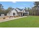 Charming farmhouse with a large front lawn, covered porch, and American flag at 3911 Peeksville Rd, Locust Grove, GA 30248