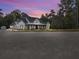Charming modern farmhouse with black trim, white siding, and inviting front porch at dusk at 3911 Peeksville Rd, Locust Grove, GA 30248
