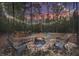 Charming firepit area surrounded by trees, enhanced with string lights for evening ambiance at 3911 Peeksville Rd, Locust Grove, GA 30248