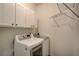 Convenient laundry room with modern washer and dryer, white cabinets, and storage shelves at 3769 Baxley Point Dr, Suwanee, GA 30024