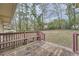 View of backyard deck with wood bench overlooking spacious backyard with mature trees and minimal foliage at 2102 Red Berry Sw Ln, Marietta, GA 30008