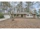 Charming ranch-style home featuring a brick facade and a well-maintained front yard with mature trees at 2102 Red Berry Sw Ln, Marietta, GA 30008