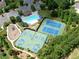 Aerial view showcases community pool, tennis courts, basketball courts, and playground, with trees surrounding at 452 Eagles Nest Cir, Auburn, GA 30011