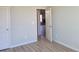 Bedroom with gray walls and light laminate flooring. Doorway leads to another room at 452 Eagles Nest Cir, Auburn, GA 30011
