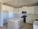 Kitchen boasts a center island, white cabinets, stainless steel appliances, and modern pendant lighting at 452 Eagles Nest Cir, Auburn, GA 30011