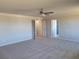 Spacious main bedroom featuring neutral carpeting, white trim, a ceiling fan and ensuite bath at 452 Eagles Nest Cir, Auburn, GA 30011