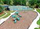 Community playground sits next to tennis courts on mulch surrounded by green lawns at 452 Eagles Nest Cir, Auburn, GA 30011