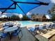 Community pool features seating, shade umbrellas, and green landscaping for leisure at 452 Eagles Nest Cir, Auburn, GA 30011